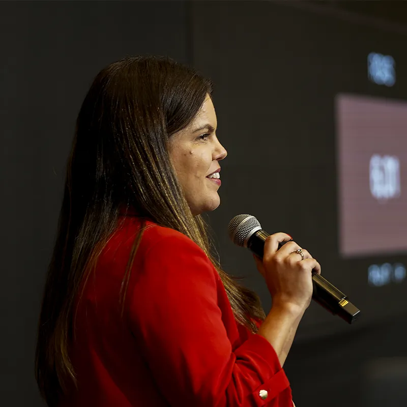 Luana Dias no palco falando para empresários do ramo gráfico